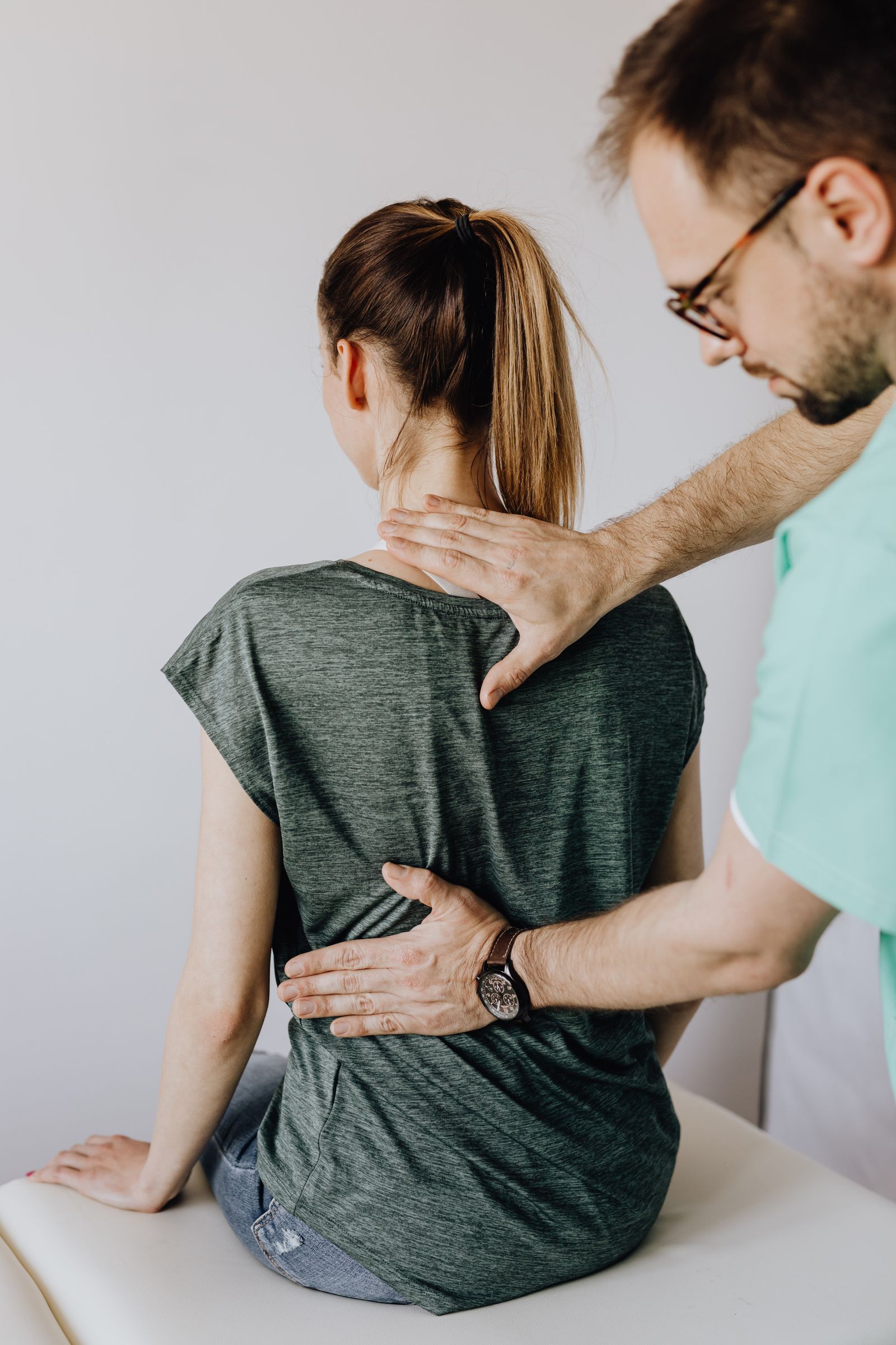 Physiotherapist examining a patient's back and spine during a consultation at Gillani Physio