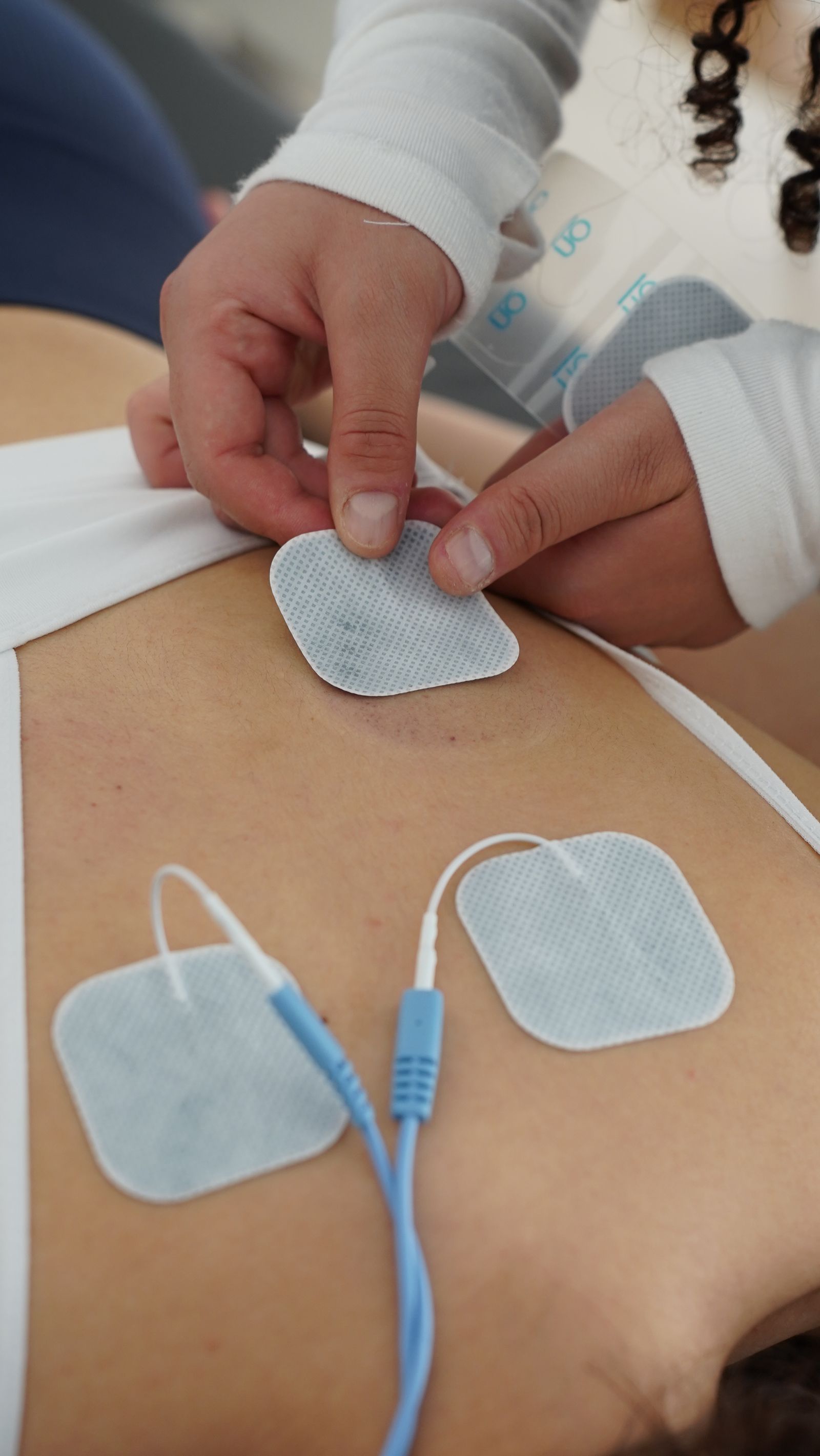Electrotherapy pads applied to a patient's back for muscle stimulation therapy