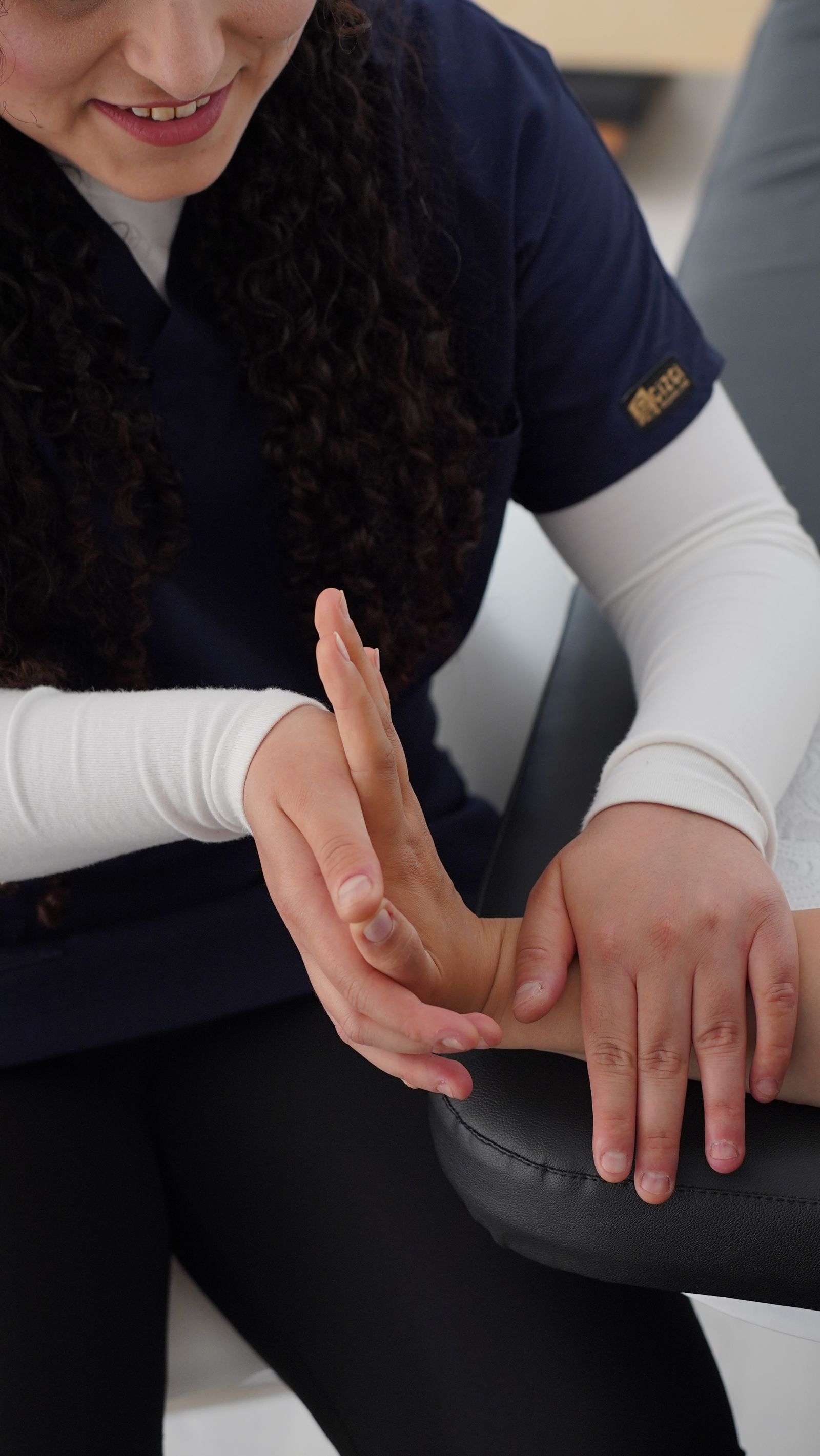Physiotherapist performing hand and wrist mobility therapy on a patient