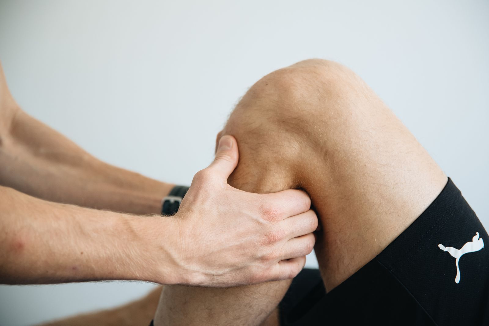Close-up of a physiotherapist massaging a patient's knee during treatment